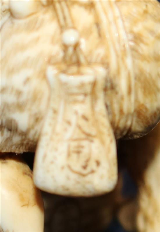 A Japanese ivory netsuke of an oni leaning on a cooking cauldron for rice, signed Tomomasa, 19th century, 4cm, loss to one toe